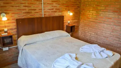 a bedroom with a bed and a brick wall at Holiday Home Alta Vista in Mina Clavero