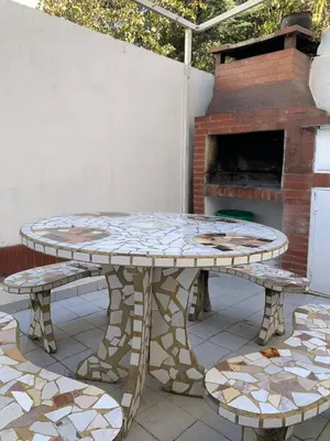 a table and benches on a patio with a fireplace at Duplex Tupungato in Villa Carlos Paz