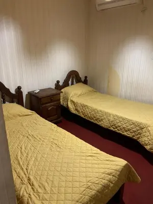 a hotel room with two beds and a wooden table at Duplex Tupungato in Villa Carlos Paz
