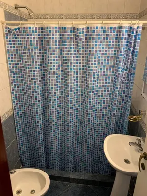 a bathroom with a blue shower curtain and a sink at Duplex Tupungato in Villa Carlos Paz