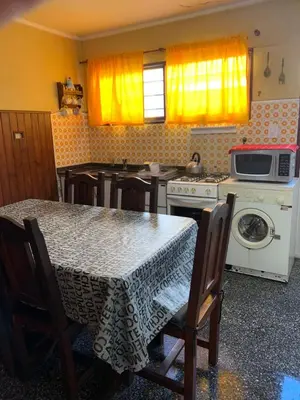 a kitchen with a table with chairs and a microwave at Duplex Tupungato in Villa Carlos Paz