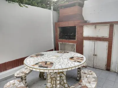 a table sitting on a patio with a fireplace at Duplex Tupungato in Villa Carlos Paz