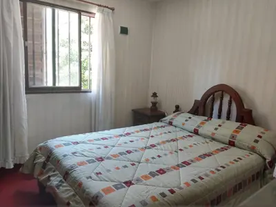 a bedroom with a bed with a quilt on it at Duplex Tupungato in Villa Carlos Paz