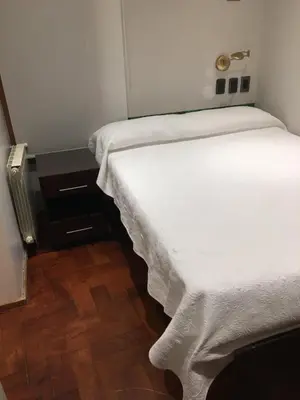 two beds in a small room with white sheets at Abudé - Zona Norte, a cuadras de Sanatorio Allende Cerro, Hospital Privado y Estadio Kempes in Cordoba