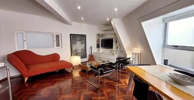 a living room with a red couch and a table at Dúplex de Diseño en Nueva Córdoba in Cordoba