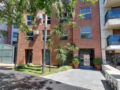 a red brick building with a sidewalk in front of it at Dúplex de Diseño en Nueva Córdoba in Cordoba