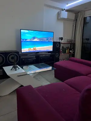 a living room with a large tv and purple furniture at Departamento PREMIUM Córdoba in Cordoba