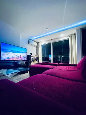 a living room with purple beds and a flat screen tv at Departamento PREMIUM Córdoba in Cordoba