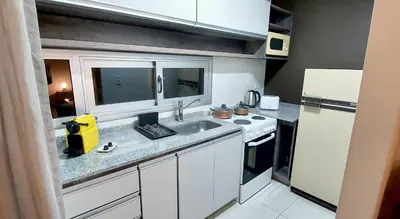 a small kitchen with a sink and a refrigerator at Departamento zona Tribunales in Cordoba