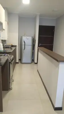 a kitchen with a white refrigerator in a room at Descanso Berenice in Villa Carlos Paz