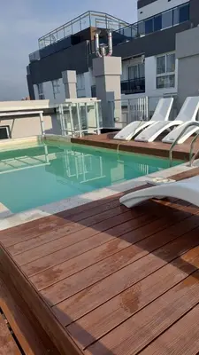 a swimming pool with lounge chairs on a building at Descanso Berenice in Villa Carlos Paz