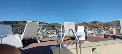a group of white chairs sitting on a roof at Descanso Berenice in Villa Carlos Paz
