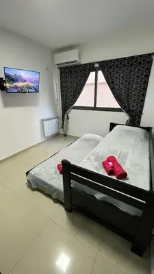 a bedroom with a bed with red slippers on it at DEPARTAMENTO en VILLA CARLOS PAZ 4P in Villa Carlos Paz