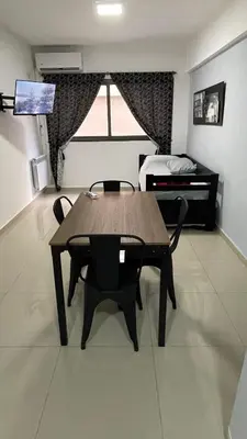 a dining room with a table and chairs and a bed at DEPARTAMENTO en VILLA CARLOS PAZ 4P in Villa Carlos Paz