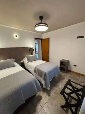 a bedroom with two beds and a light fixture at The View in Villa General Belgrano