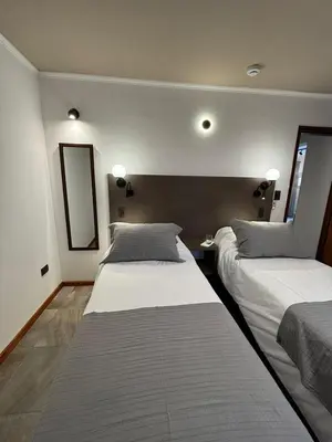 a bedroom with two beds and a mirror on the wall at The View in Villa General Belgrano