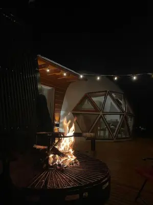 a fire pit in the middle of a patio at night at Amawa Domo - escapada romántica en las sierras in San Francisco del Monte de Oro