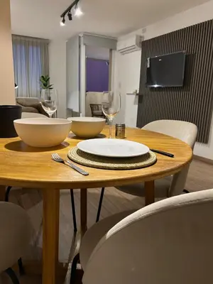 a wooden table with bowls and wine glasses on it at Departamento balcones de Cofico in Cordoba