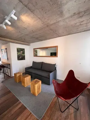 a living room with a couch and a red chair at De lo mejor en Barrio General Paz in Cordoba