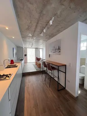 a kitchen and living room with a counter and a table at De lo mejor en Barrio General Paz in Cordoba