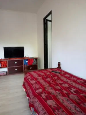 a bedroom with a red bed and a tv at Casa en Villa Los Aromos cerca del río in Villa Los Aromos