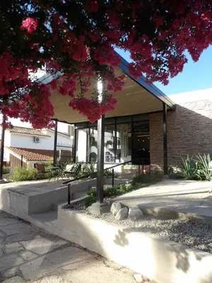 a building with a tree in front of it at Nova Hotel Boutique in Villa Carlos Paz