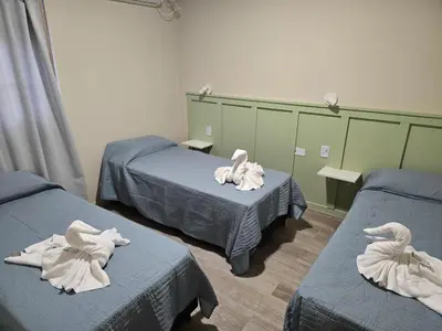 a room with two beds with towel swans on them at Nova Hotel Boutique in Villa Carlos Paz