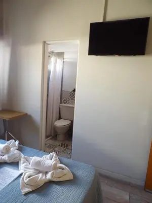 a bedroom with a bed and a bathroom with a toilet at Nova Hotel Boutique in Villa Carlos Paz