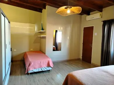 a room with two beds and a lamp and a mirror at Dúplex 250ms Peatonal in Villa Carlos Paz