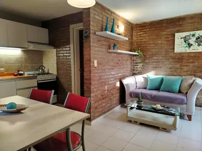 a kitchen and a living room with a couch and a table at Dúplex 250ms Peatonal in Villa Carlos Paz