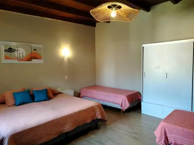 a bedroom with two beds and a chandelier at Dúplex 250ms Peatonal in Villa Carlos Paz