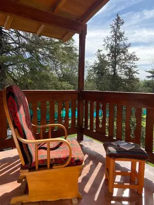 a rocking chair sitting on a porch with a table at Casa RINCON DEL SOL in La Bolsa