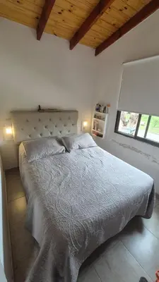 a bedroom with a bed in a room with a window at La Maga in Santa Rosa de Calamuchita