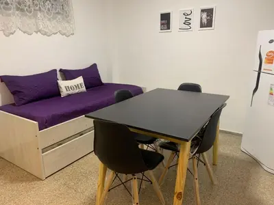 a room with a bed and a table and chairs at Departamento Costanera in Villa Carlos Paz