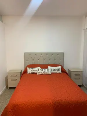 a bedroom with a red bed with two night stands at Departamento Costanera in Villa Carlos Paz