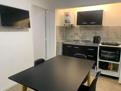 a kitchen with a black table and chairs in it at Departamento Costanera in Villa Carlos Paz