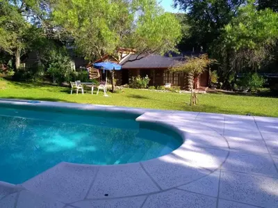 a swimming pool in a yard with a house at Cabaña La Cotita in Villa Los Aromos