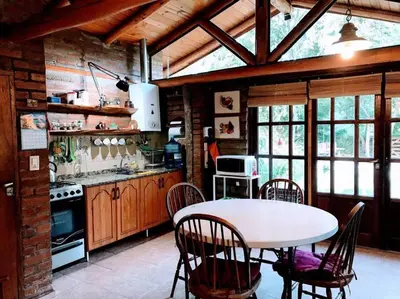 a kitchen with a table and chairs in a room at Cabaña La Cotita in Villa Los Aromos