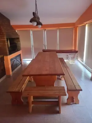 a wooden table and benches in a room at Bialet Masse hermosa casa con pileta in Cordoba