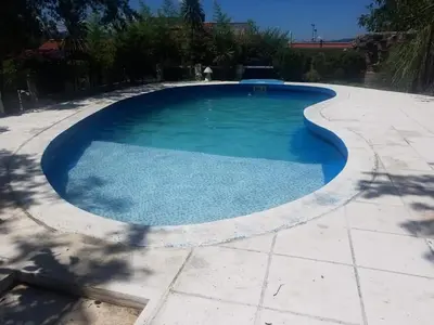a swimming pool with a curved coping in a backyard at Bialet Masse hermosa casa con pileta in Cordoba