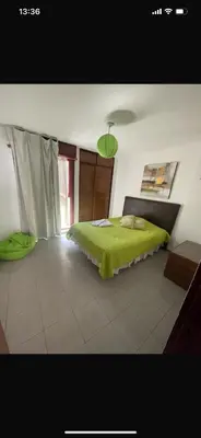 a bedroom with a bed with a green blanket at Depto chacabuco in Cordoba