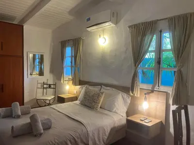 a bedroom with a large bed with two windows at ApartQ, depto entero, Villa Belgrano, Córdoba capital in Cordoba