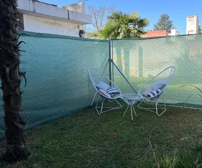 two chairs and a swing on a fence at ApartQ, depto entero, Villa Belgrano, Córdoba capital in Cordoba