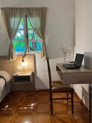 a bedroom with a desk with a laptop on it at ApartQ, depto entero, Villa Belgrano, Córdoba capital in Cordoba