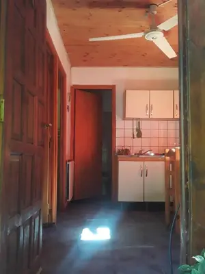 an empty kitchen with a red door in a room at Cabañas La Fiaca in Los Manantiales