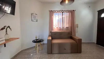 a living room with a chair and a table at 760 A Apartamentos in Alta Gracia