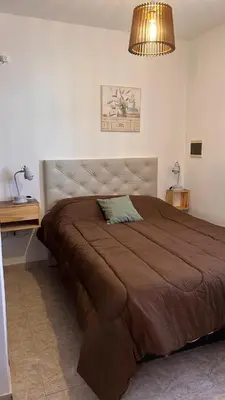 a bedroom with a large bed with a brown blanket at 760 A Apartamentos in Alta Gracia