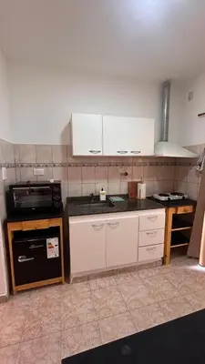 a kitchen with white cabinets and a stove top oven at 760 A Apartamentos in Alta Gracia