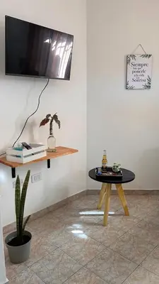 a room with a table and a tv on a wall at 760 A Apartamentos in Alta Gracia