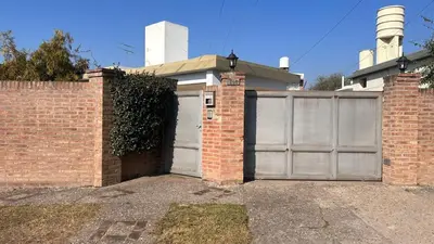 a house with a garage with a brick wall at 760 A Apartamentos in Alta Gracia